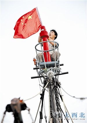 7月31日，海南琼海潭门港的渔民在桅杆上悬挂国旗。