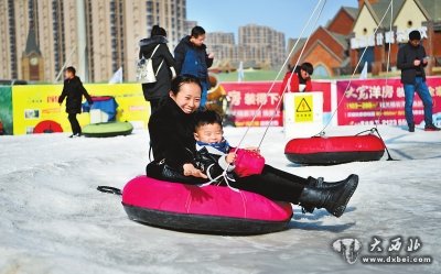 市民带着孩子在甘肃国际会展中心滑雪场体验滑雪的乐趣